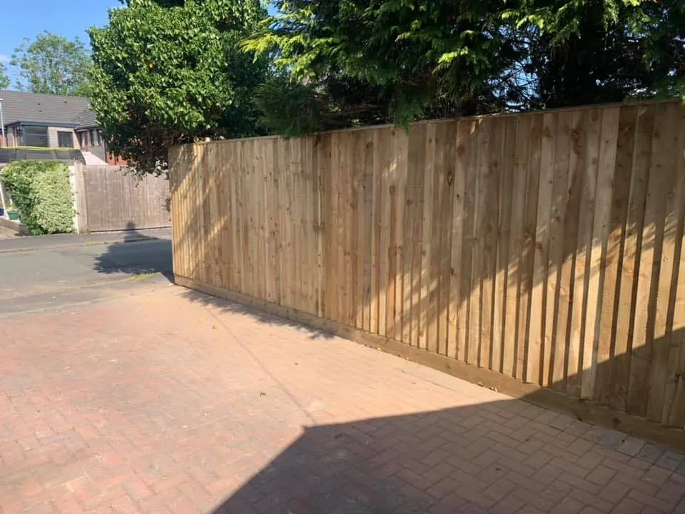 Close-board fencing along a driveway
