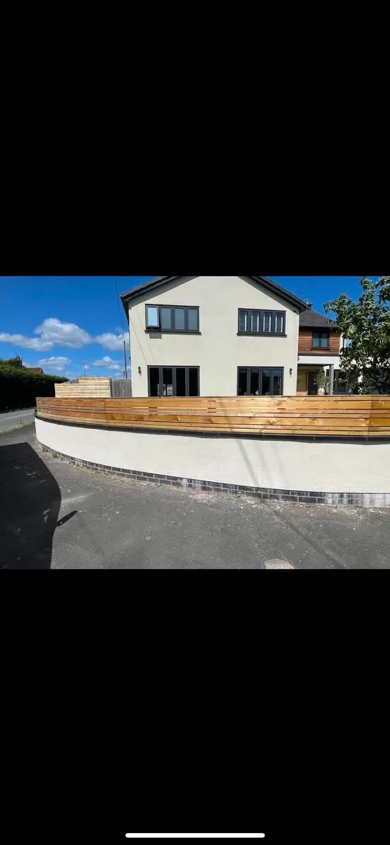 Curved horizontal timber fence on rendered wall