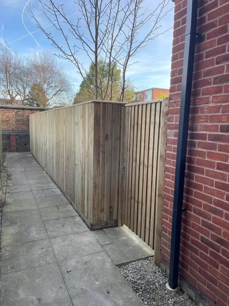 Tall fencing and matching gate along path