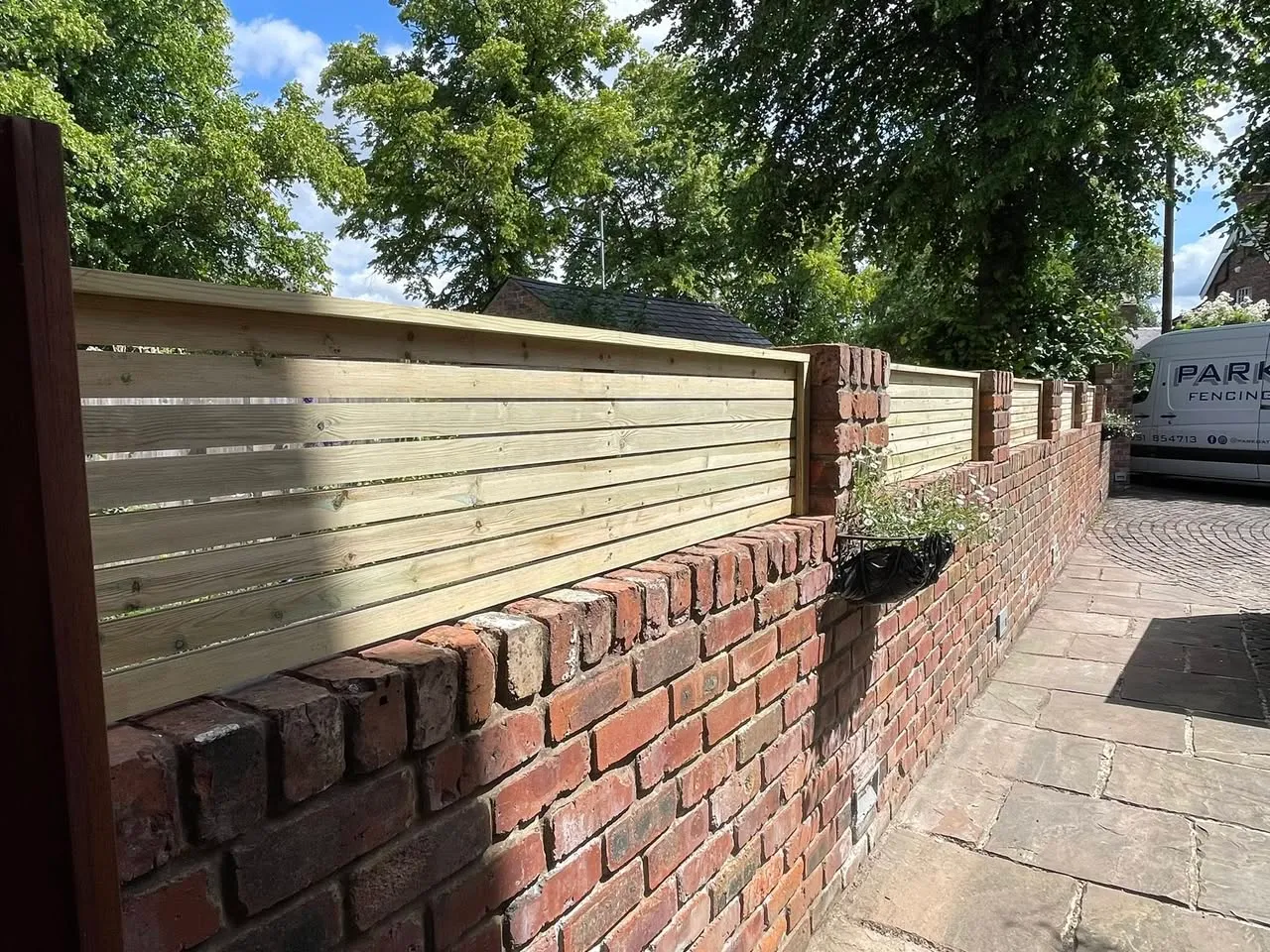 Horizontal slat fencing on brick wall