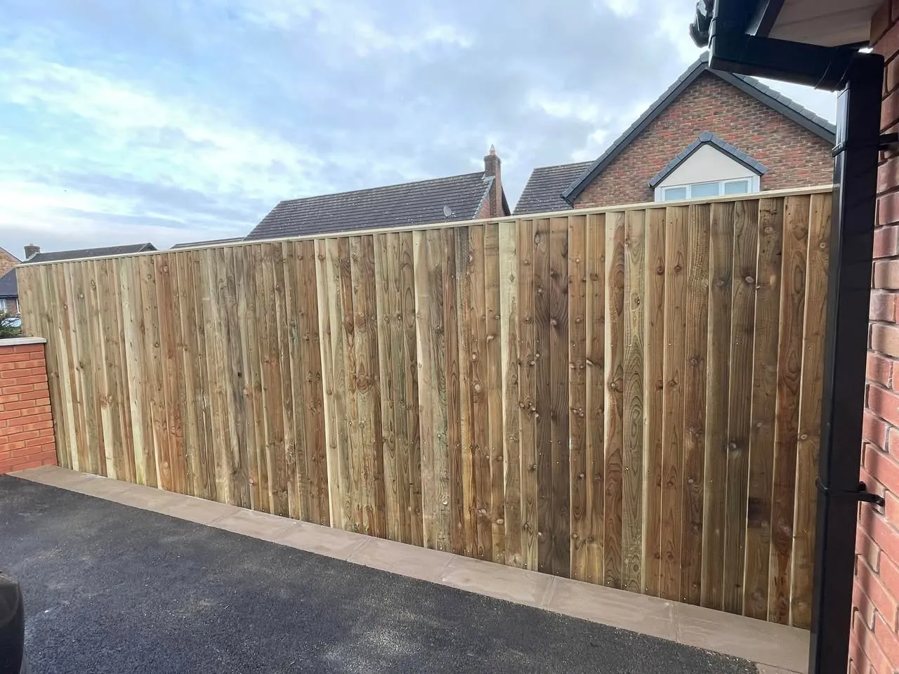 Tall close-board fencing with dramatic sky